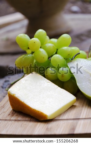  - stock-photo-french-cheese-saint-paulin-with-pear-and-grape-on-the-board-in-the-garden-155206268