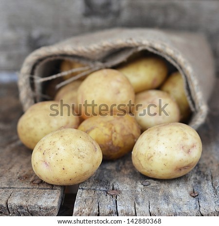 Про стоки Sack fresh organic potatoes on a wooden table - stock photo