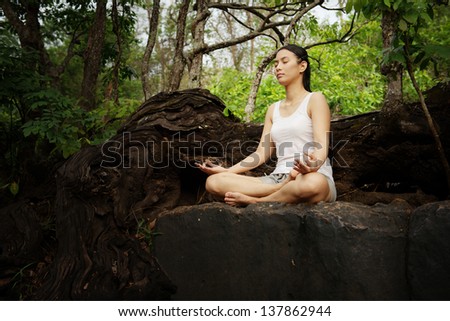 Woman training yoga and meditation on the rock at the mountain - stock ...