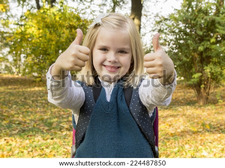 schoolgirl holding book and smiling in the park - stock photo schoolgirl holding book and smiling in the park - stock photo
