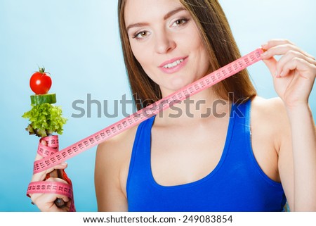 Sporty girl fitness woman holding fork with fresh mixed vegetables and - stock-photo-dieting-weight-loss-concept-sporty-girl-fitness-woman-holding-fork-with-fresh-mixed-vegetables-and-249083854