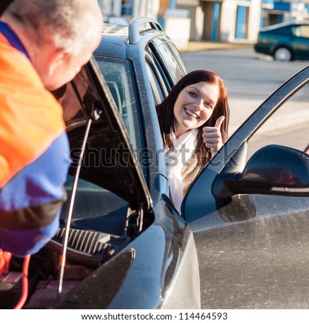 Mechanic fixing car happy woman thumb up breakdown problem