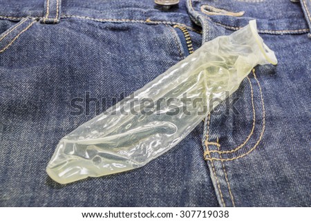 stock-photo-used-condom-condom-in-the-hands-on-jeans-texture-background-307719038.jpg