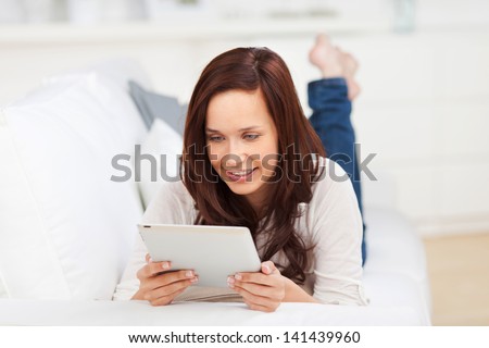 http://thumb1.shutterstock.com/display_pic_with_logo/321598/141439960/stock-photo-woman-relaxing-lying-on-her-stomach-on-a-sofa-reading-information-on-a-tablet-computer-141439960.jpg