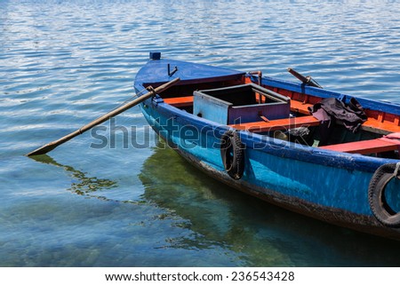 Antique, old wooden fishing boat with oars on lake in Chile - stock 