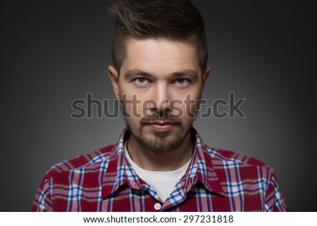 Portrait of serious handsome man on dark grey background. - stock-photo-portrait-of-serious-handsome-man-on-dark-grey-background-model-in-plaid-shirt-with-eyes-like-297231818