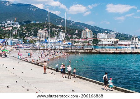 YALTA - June 10, 2014: People relax and swim at the beach in Yalta