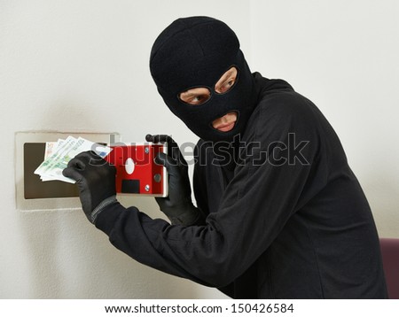 Thief burglar stealing euro money during home safe codebreaking - stock photo