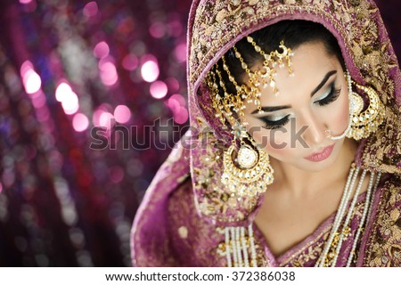 Portrait of a Beautiful Elegant Female Model in Traditional Ethnic Indian Asian Bridal  Costume with Makeup and Heavy Jewellery - stock photo