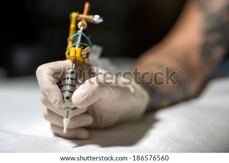 Tattoo artist at work. Closeup - stock photo