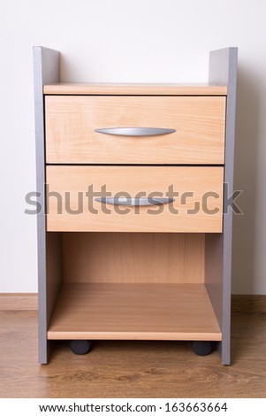 modern wooden nightstand on the floor in bedroom - stock photo