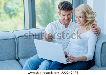 http://thumb1.shutterstock.com/display_pic_with_logo/61004/222249424/stock-photo-young-couple-sitting-sharing-a-laptop-computer-as-they-sit-close-together-on-a-comfortable-couch-in-222249424.jpg