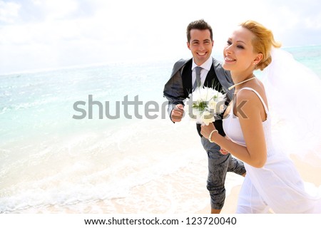 http://thumb1.shutterstock.com/display_pic_with_logo/624661/123720040/stock-photo-just-married-couple-running-on-a-sandy-beach-123720040.jpg