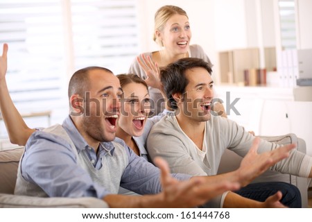 stock-photo-cheerful-group-of-friends-watching-football-game-on-tv-161444768.jpg