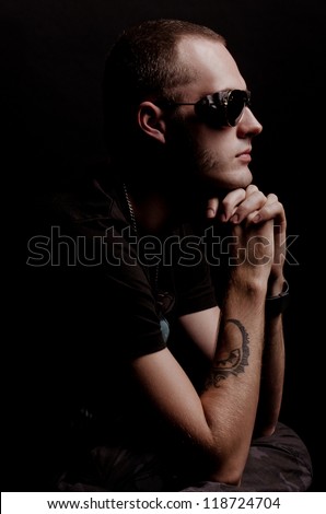 Attractive audacious man in dark glasses, sitting on a chair - stock photo - stock-photo-attractive-audacious-man-in-dark-glasses-sitting-on-a-chair-118724704