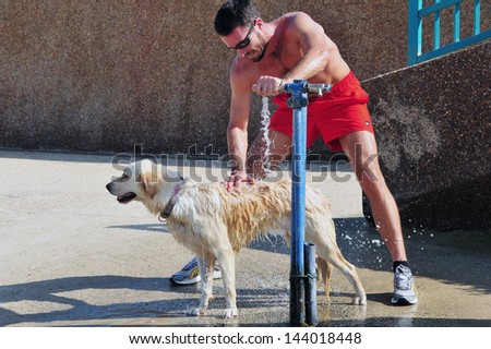 ASHKELON, ISR - NOV 13: Israeli man cools his dog down during heatwave ... ASHKELON, ISR - NOV 13: Israeli man cools his dog down during heatwave ...