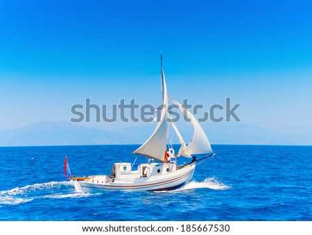 Old classic wooden Greek boat (Kaiki) with sails during a Classic 