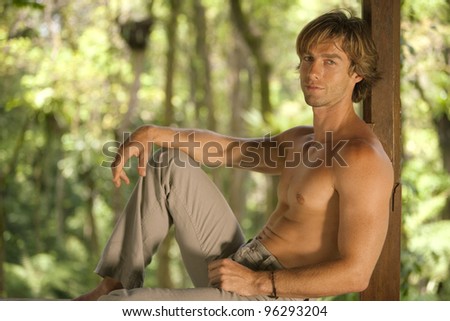 stock photo man sitting down on a wooden structure in the rain forest 96293204