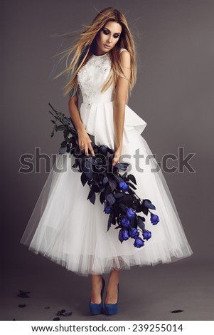 stock-photo-beautiful-model-posing-in-wedding-dress-with-blue-roses-in-her-hands-239255014.jpg