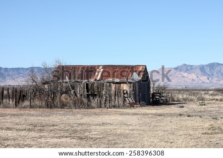 Old little building with wooden board walls and corrugated tin roof in 