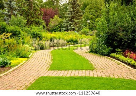 An empty path through the park in the summer day - stock photo