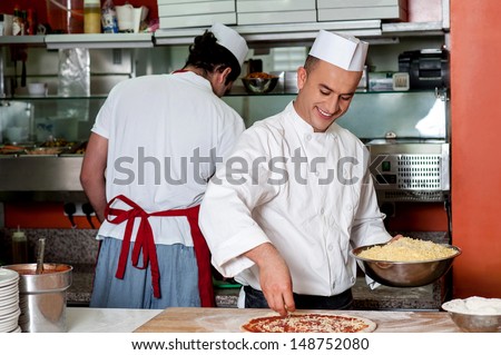 Male chefs working in kitchen, back-office shot - stock photo