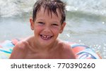 Small photo of Boy in inflatable ring floating on the sea all wet and happy
