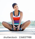 Beautiful woman exercising outdoors and looking very happy - stock photo