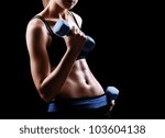 Closeup photo of a fitness model body on black background - stock photo