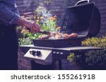 man cooking meat on barbecue