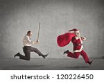 Santa Claus running away from a man who pursues him with a stick - stock photo