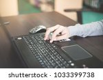 Small photo of Close up business person's hands using computer on wooden table outside the office in weekend. Woman's hands using laptop computer access internet searching information for work outside work place.