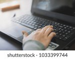 Small photo of Close up business person's hands using computer on wooden table outside the office in weekend. Woman's hands using laptop computer access internet searching information for work outside work place.