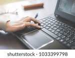 Small photo of Close up business person's hands using computer on wooden table outside the office in weekend. Woman's hands using laptop computer access internet searching information for work outside work place.