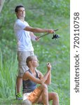Small photo of guy is holding a fishing rod and girlfriend talking picture