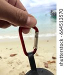 Small photo of picking up red carabiner on the beach