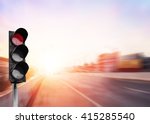 Small photo of Red traffic light on the expressway asphalt road with car in a city landscape at sunrise. light sign for car stop and speed reduction. Dangerous,warning signal,semaphore driving. Driving on a Highway.