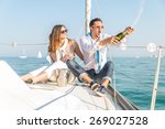 Small photo of Couple celebrating with champagne on a boat .Attractive man uncorking champagne and having party with girlfriend on vacation.Two young tourists having fun on boat tour in the summertime
