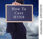 Small photo of A women holding a chalk board with word " HOW TO CURE H5N8 " isolated in a background of blue sky. H5N8 is a subtype of the Influenza A virus.