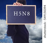 Small photo of A women holding a chalk board with word " H5N8 " isolated in a background of blue sky. H5N8 is a subtype of the Influenza A virus.