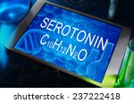 Small photo of the chemical formula of serotonin on a tablet with test tubes