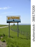 Small photo of Welcome to Wyoming state sign with the Wyoming landscape of open plains and mountains in the background. / Welcome to Wyoming