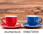 Small photo of Empty mugs on saucers. Cups on wooden backdrop. Make a break.