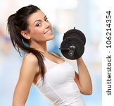 portrait of a young pretty woman holding weights and doing fitness indoor - stock photo