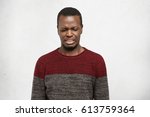 Small photo of Eww. Headshot of disgusted or contempted young African American man looking down, feeling loathing and aversion towards something, making wry mouth, having fastidious and squeamish expression