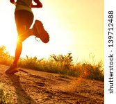 Young lady running on a rural road during sunset - stock photo