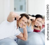 Portrait of happy group exercising on Swiss ball - stock photo