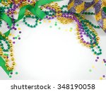 Small photo of Carnival and Mardi Gras items including harlequin mask, green, gold and purple beads and ribbons and confetti on a warm white background. Copy space for your message. Horizontal composition