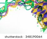 Small photo of Carnival and Mardi Gras items including harlequin mask, green, gold and purple beads and ribbons and confetti on a warm white background. Copy space for your message. Horizontal composition