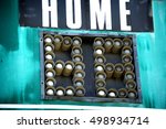 Small photo of aged and worn vintage sports scoreboard with bulbs